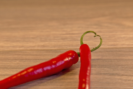 Showing 2 chillies with their stalks placed together to form a heartの写真素材