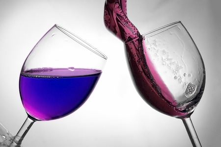 Fluid motion of coloured water in a wine glass with blownout highlightsの写真素材