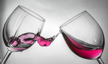 Fluid motion of coloured water in a wine glass with blownout highlightsの写真素材
