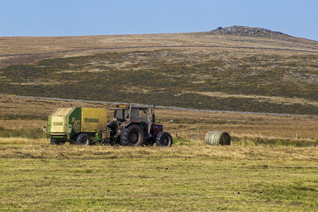 Postbridge, Devon, UK October 1 2015 - Showing a tractor, driver and round bailer, on a farm on the darmoor national park.のeditorial素材