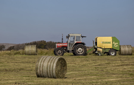 Postbridge, Devon, UK October 1 2015 - Showing a tractor, driver and round bailer, on a farm on the darmoor national park.のeditorial素材