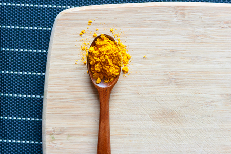 Curcuma (turmeric) powder in wooden spoonの写真素材