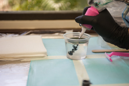 Tattoo artist hand dipping the needle for first time.の写真素材