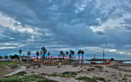 Panoramic of Ventura Marina Park lights shining under threatening clouds.