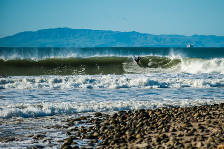 Surfer hitting lip as waves closes out with Santa Cruz Island in background.の写真素材