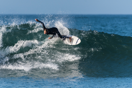 Surfer in black wetsuit ftakes a big and sweeping turn at Surfer's Knoll, Ventura, California on October 1, 2018.のeditorial素材