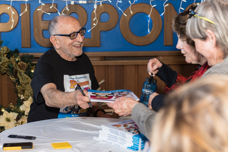 Author, Ivor Davis handing a signed copy at book signing at Pierpont Racquet Club in Ventura, California, USA on December 1, 2018.のeditorial素材