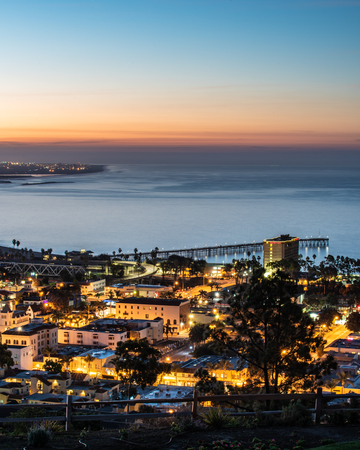 Downtown Ventura, California, USA is nestled against the Pacific Ocean coastline and lit up as the...