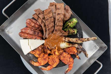 Meat loved dream with a bucket full of carne asada, shrimp, shallots, and grilled peppers.