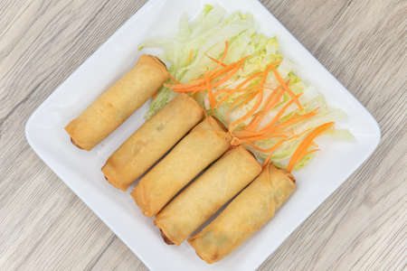 Overhead view of deep fried egg rolls arranged on a plate as an appetizer for your meal.