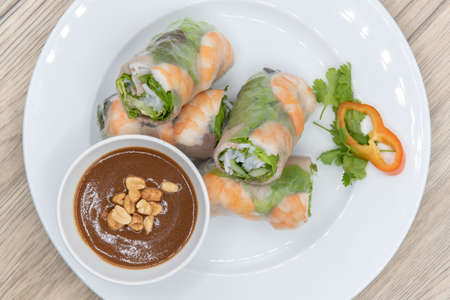 Overhead view of hearty plate of tofu spring rolls loaded and sliced for a complete appetizer.