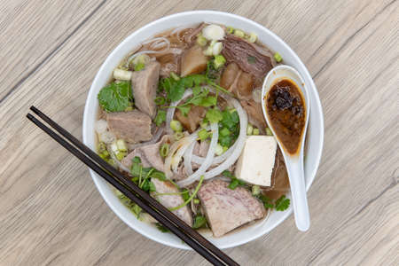 Overhead view of hearty bowl of Pho loaded with meat, broth, and special taro sauce for a complete meal.の写真素材