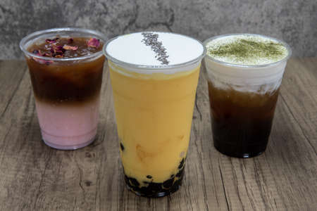 Orange mango latte cold beverage mixes iced boba drink for a refreshing beverage among other choices.の写真素材