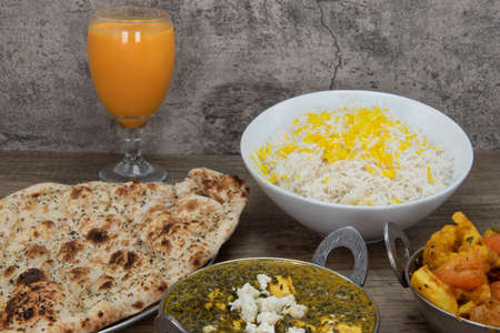 Garlic flavored naan bread from Indian restaurant part of huge table feast with mango lassi and sag...