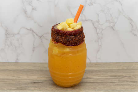 Mango infused water with slices of fruit filled to the top with a seasoned flavored rim.の写真素材