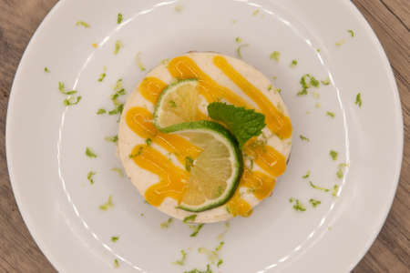 Overhead view of hearty key lime pie decorated with icing, lime slice, and mint leaf.の写真素材