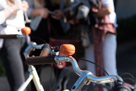 Orange bell attached to the bike handlebars to alert others while riding.の写真素材