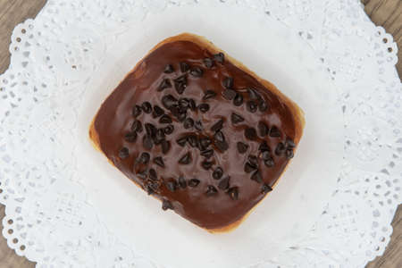Overhead view of tempting fresh from the oven chocolate chocolate chip donut from the bakery served on a plate.の写真素材