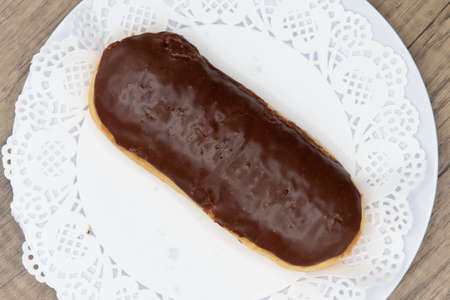 Overhead view of tempting fresh from the oven chocolate bar donut from the bakery served on a plate.
