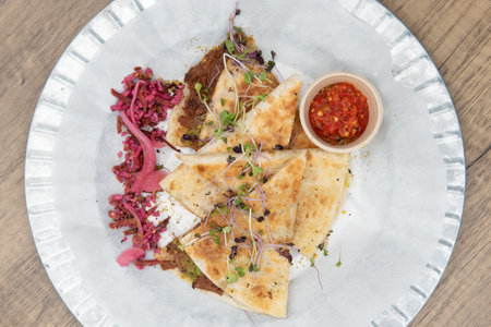 Overhead view of nutritious cheese quesadilla with BBQ jerk jackfruit on a tortilla will start any...