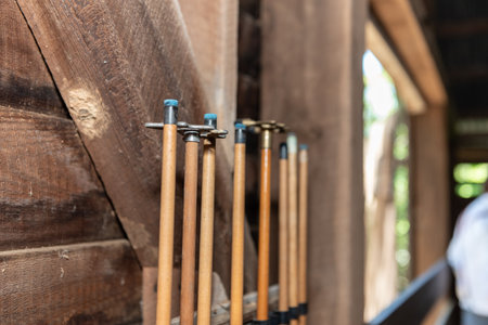 Blue tips of the pool cues are stored upright against the wooden barn wall.の写真素材