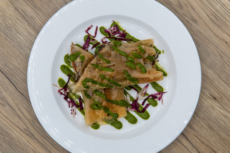 Overhead view of tempting appetizer of mushroom strudel in filo dough served on a small plate.