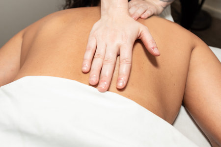 Massage therapist strong hands provide long and steady palm pressure on muscle stimulating strokes.の写真素材