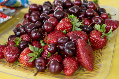 Plate of strawberries and cherries are washed and ready to be eated by the guests.の写真素材