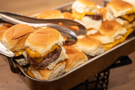 Cheeseburger sliders were out on serving dishes for party guest still hungy to eat.の写真素材