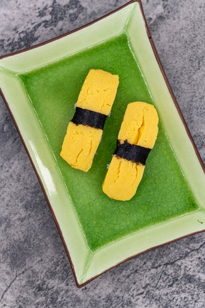 Overhead view of sushi plate with a pair of egg nigiri as an appetizer.の写真素材