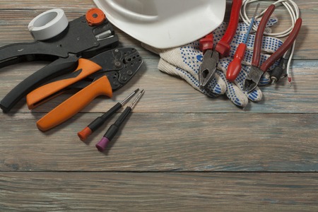 Set of electrical tool on wooden background.