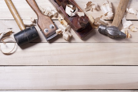 Construction tools on wooden table with sawdust.