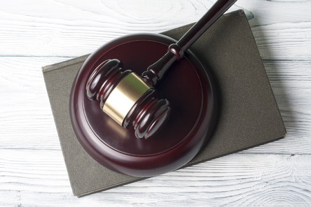 Book with wooden judges gavel on tableの写真素材