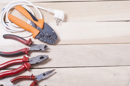 Set of electrical tool on wooden background.