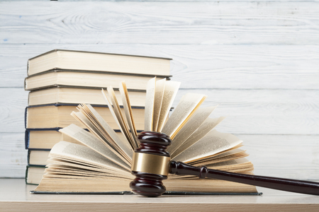 Book with wooden judges gavel on table in a courtroom or enforcement officeの写真素材