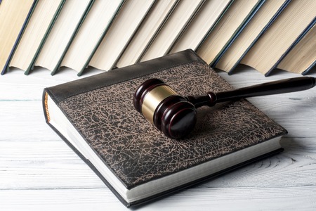 Book with wooden judges gavel on table in a courtroom or enforcement officeの写真素材