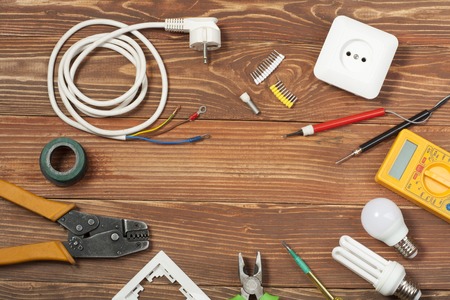 Set of electrical tool on wooden background. Accessories for engineering work, energy conceptの写真素材