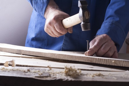 Carpenter working with plane on wooden background at Building Site. Joiner workplace.の写真素材