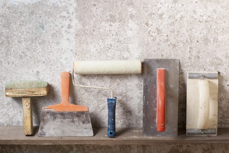 Construction tools on concrete background. Copy space for text. Set of assorted plaster trowel tools...