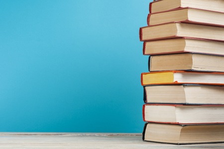 Stack of colorful books on the wooden table. Education background. Back to school. Copy space for...
