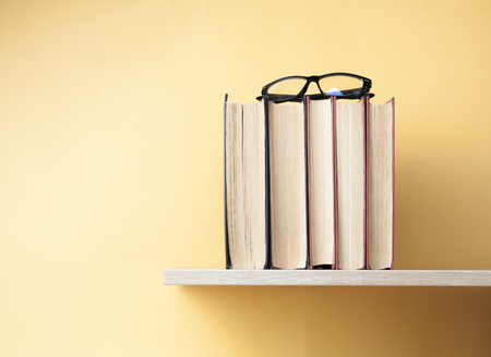 Stack of books on wooden shelf. Education background. Back to school. Copy space for text.