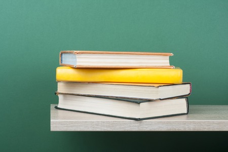 Stack of books on wooden shelf. Education background. Back to school. Copy space for text.の写真素材
