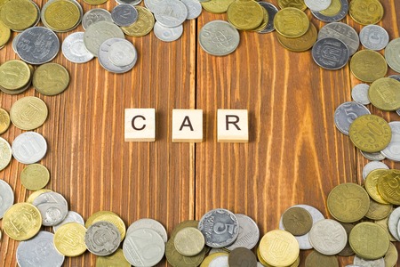Word CAR on wooden cube with coins frame at wood background. Finance concept.の写真素材