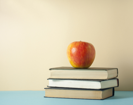 Stack of books and apple on wooden table. Education background. Back to school. Copy space for text.の写真素材