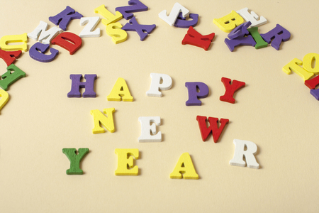 Text HAPPY NEW YEAR on yellow background written on colorful blocks of alphabet. Holiday concept.の写真素材