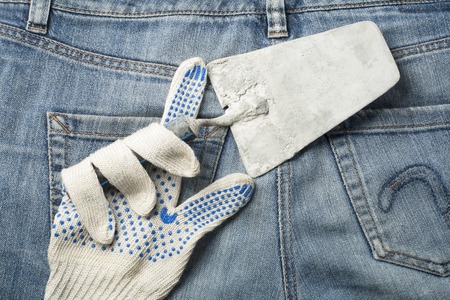 Working glove with plastering tool on the background of jeans.Top view.の写真素材