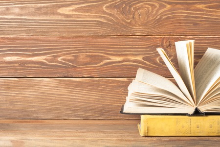 Open book, hardback books on wooden table. Education background. Back to school. Copy space for text.の写真素材