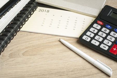 Financial and budget concept. Accounting books, calculator, pen and calendar on office tableの写真素材