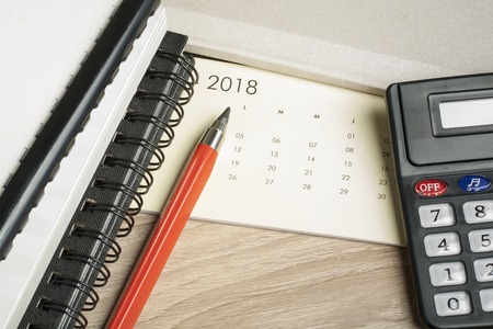 Financial and budget concept. Accounting books, calculator, pen and calendar on office tableの写真素材