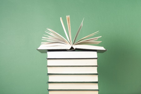 Open book on stack of books on wooden table. Education background. Back to school.の写真素材